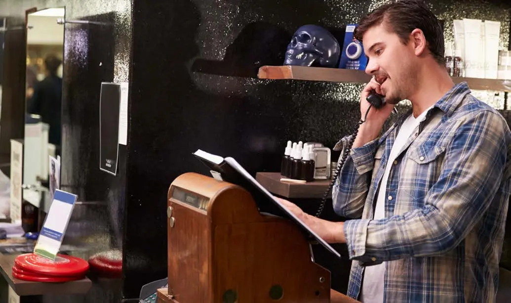 Small business owner using a telephone at work